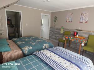 1 dormitorio con 2 camas, mesa y escritorio en Private Large double room, en Auckland