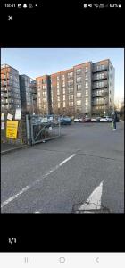 an empty parking lot with a building in the background at Waterfront, Ethihad stadium apartments in Manchester