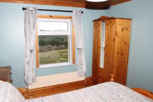 a bedroom with a bed and a window at Biddy Rua's Place in Killybegs