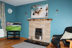 a living room with a fireplace and a tv at Biddy Rua's Place in Killybegs