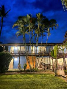 a house with palm trees in front of it at Maresias de Itu Suites pertissimo da praia com piscina in Maresias