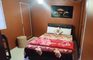 a bedroom with a bed with a red comforter at Townside Lodge in Nuwara Eliya