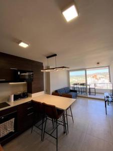 cocina y sala de estar con mesa y sillas en Hermoso departamento 2 dormitorios +2 baños, nuevo, ubicación perfecta, en Viña del Mar