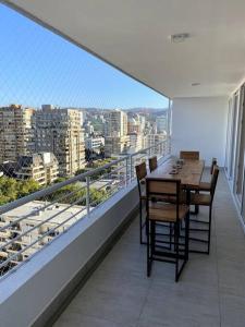 balcón con mesa, sillas y vistas a la ciudad en Hermoso departamento 2 dormitorios +2 baños, nuevo, ubicación perfecta, en Viña del Mar