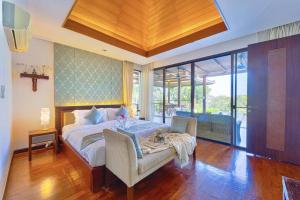 una camera da letto con un letto e una sedia di 3 Bed Luxury Bali Style Villa Close To Beach PR6 a Ban Bo Kaeo Altre 35 foto