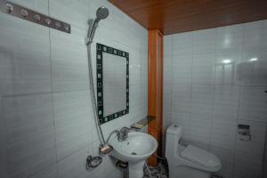 a bathroom with a sink and a toilet and a mirror at OH Pu Luong Homestay in Hương Bá Thước