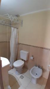 a bathroom with a toilet and a sink at Acutun in Mar de Ajó