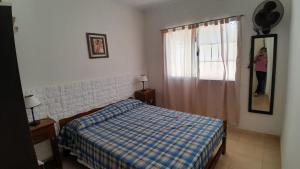 a bedroom with a bed and a woman standing in a window at Acutun in Mar de Ajó