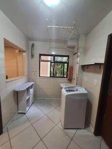 bagno con lavandino e lavatrice di Aconchegante no centro de Nova Friburgo a Nova Friburgo