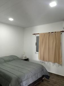 1 dormitorio con cama y ventana en Complejo - LA ZULA - en Federación