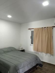 un dormitorio con una cama y una ventana en Complejo - LA ZULA - 1y2Dormitorios, en Federación