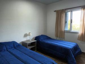 a bedroom with two blue beds and a window at Complejo - LA ZULA - 1y2Dormitorios in Federación
