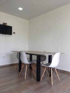 mesa con 4 sillas y TV en la pared en Complejo - LA ZULA - en Federación