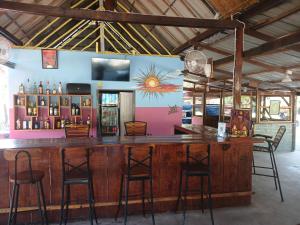 a bar in a room with chairs and a painting on the wall at Le Soleil in Kep