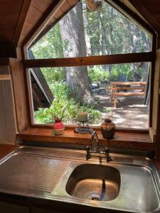 a sink in a kitchen with a window above it at Luna Roja Llao Llao in San Carlos de Bariloche