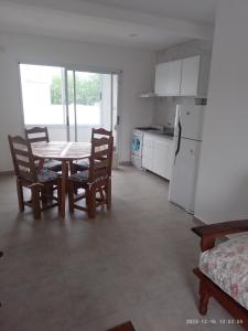 a kitchen with a table and chairs and a refrigerator at Rico in Mar de Ajó