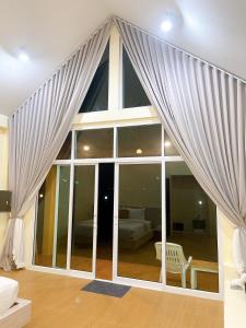uma sala de estar com uma grande janela com cortinas em Chokdee Resort em Ko Chang