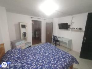 Dormitorio con cama, escritorio y TV en cerca a embajada americana Corferias centro club militar 201, en Bogotá