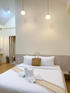 een slaapkamer met een groot wit bed met witte kussens bij Chokdee Resort in Ko Chang