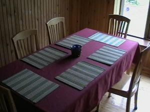Paide Homestay في Kriilevälja: طاولة أرجوانية مع أربعة كراسي وطاولة قماش أرجوانية