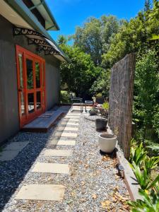 a garden with a patio and a red door at Mākoha Place in Nelson