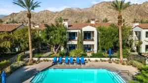 a pool with chairs and palm trees and a house at LV007 Downstairs LV Studio in a Quiet Location in La Quinta