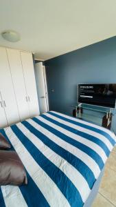 1 dormitorio con cama de rayas azul y blanco en para 2 frente al mar-9, en La Serena
