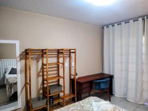 a room with a bedroom with a bed and a desk at Casa Pôr do Sol com churrasqueira ar condicionado in Florianópolis