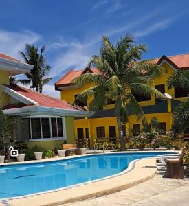 ein Haus mit einem Pool vor einem Haus in der Unterkunft Lagnason's Place in Oslob