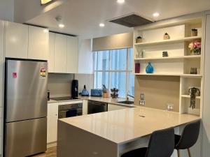 Location Location Executive Apartment في سيدني: مطبخ مع ثلاجة ستيل ستانلس وكاونتر