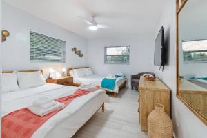 een woonkamer met 2 bedden en een televisie bij Summer By The Sea in Pompano Beach