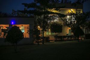 ein Gebäude mit blauem Licht in der Nacht davor in der Unterkunft Triple Tee Gardens & Accomodation in Wakiso