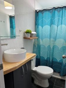 uma casa de banho com um lavatório, um WC e uma cortina de chuveiro. em Casa Entre Glaciares em Puerto Natales
