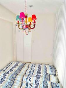 1 dormitorio con 1 cama con lámpara de araña en 『沙羅居の森Suite』便利な名古屋都心部の高級デザイナーズマンション50 ㎡ まるごと貸切最大7名 en Nagoya