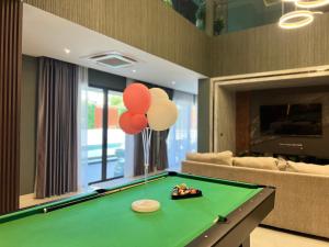 a living room with a pool table with balloons on it at Minho Villa Luxury Pattaya in Nong Prue