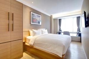 1 dormitorio con cama blanca y ventana en Bridal Tea House Hotel-Free Welcome Drink, en Guangzhou