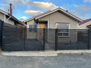 a black fence in front of a house at Casa Entre Glaciares in Puerto Natales