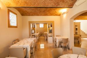 une salle à manger avec des tables et des chaises blanches dans l'établissement Hotel Villa Maranello, à Maranello