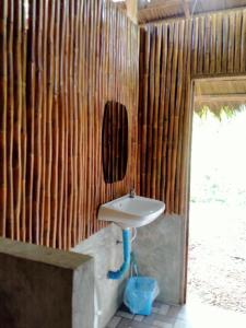 a bathroom with a sink and a wooden wall at Imsuk Bo Klua in Ban Pha Khap