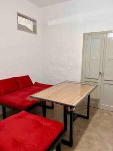 a living room with a table and a red couch at Departamento en San Francisco Isabel in San Francisco
