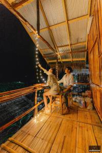 a man and a woman sitting on a wooden deck at Imsuk Bo Klua in Ban Pha Khap