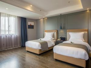 a hotel room with two beds and a window at Lano Hotel Zhenjiang South High-speed Railway Station Baolong Plaza in Zhenjiang