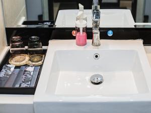 a white sink with a soap dispenser on top of it at LanOu Hotel Yellowstone Harbor Area Moore Cityland in Huangshi
