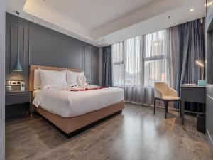 a bedroom with a large bed and a chair at Lano Hotel Guizhou Zunyi High Speed â€‹â€‹Railway Station Medi City in Zunyi