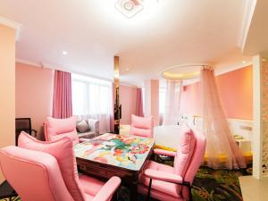 ein Wohnzimmer mit rosa Stühlen und einem Tisch in der Unterkunft Thank Inn Plus Hotel Jiangsu Taizhou Dainan Tuanjie in Shiyan
