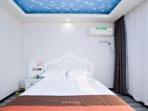 A bed or beds in a room at JUN Hotels Jiangsu Nanjing Railway Station Sun Yat-sen Mausoleum Scenic Area