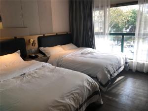 Gulta vai gultas numurā naktsmītnē JUNYI Hotel Nanjing Olympic Sports Center