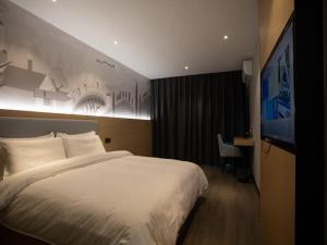 ein Hotelzimmer mit einem großen Bett und einem Schreibtisch in der Unterkunft Thank Inn Chain Hotel Hunan Huaihua Hecheng District South High Speed Rail Station in Huaihua