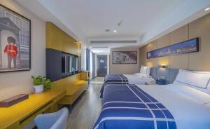 Habitación de hotel con 2 camas y TV en LanOu Hotel Chongqing Shapingba University City, en Tuzhu