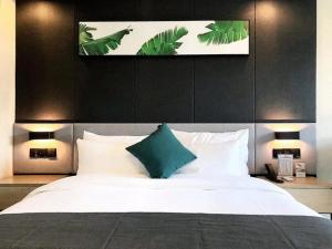 Un dormitorio con una cama grande con almohadas verdes y blancas en Thank Inn Chain Hotel Chongqing Wuxi County Shuangzitian Street, en Wuxi